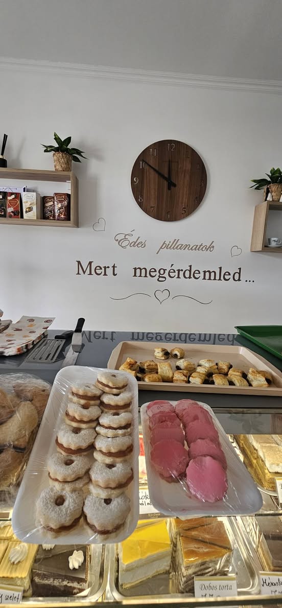 Linzerkarikák és rózsaszín sütemények a pulton.